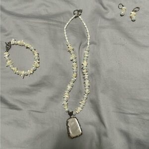 Silver jewelry pendant wrapped around seashells and pearls set